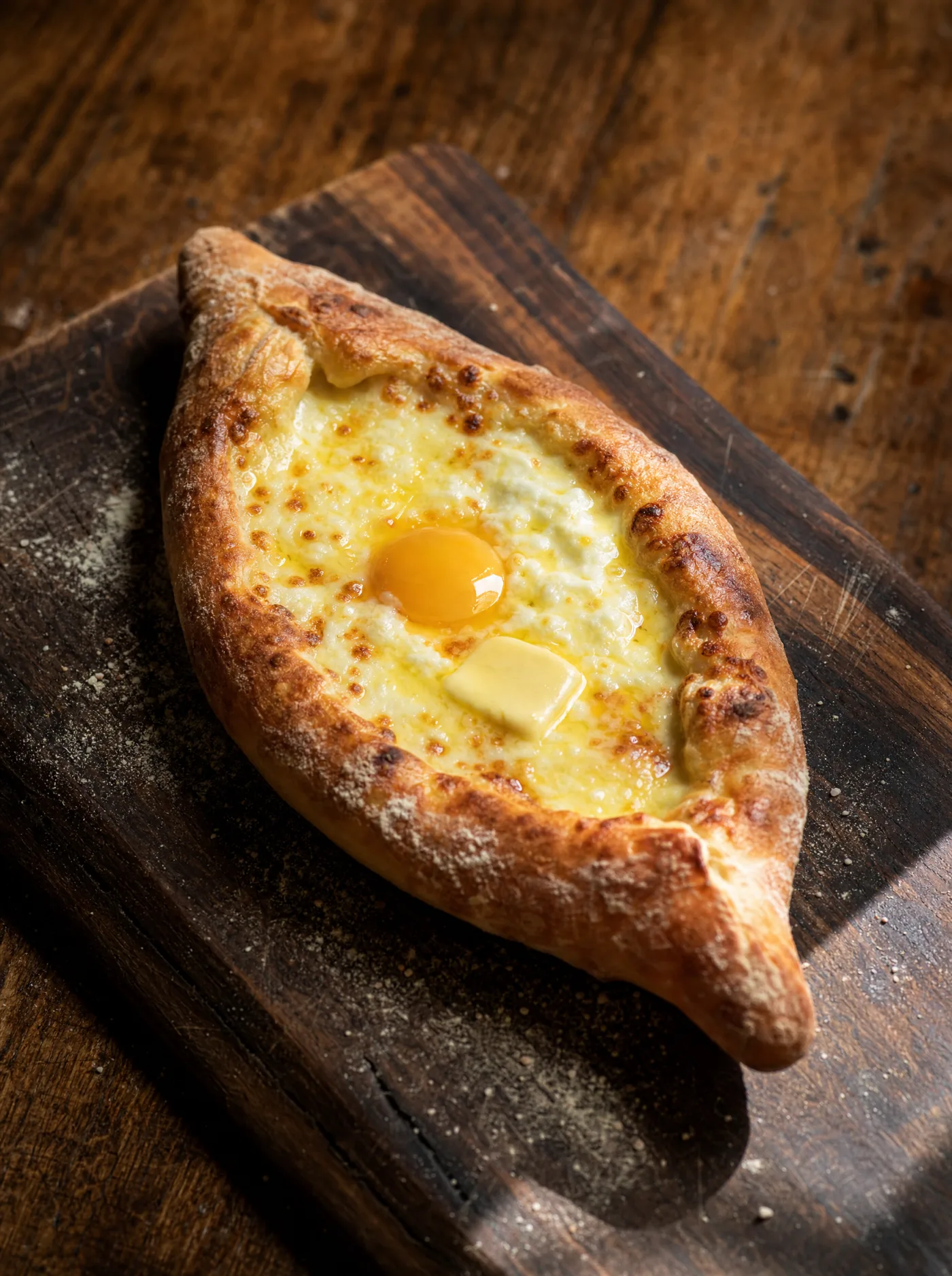 Acharuli khachapuri — boat-shaped Georgian cheese bread with melted cheese and egg yolk